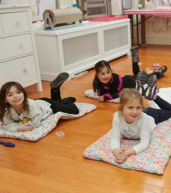 Three girls laying on pet blanket in craft workshop