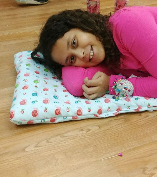 A girl laying on a pet blanket